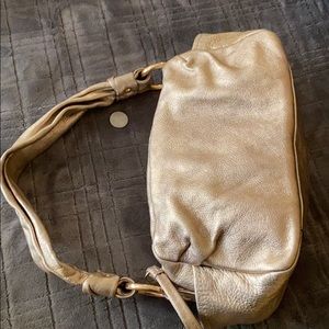 Coach metallic gold with a rose hint color